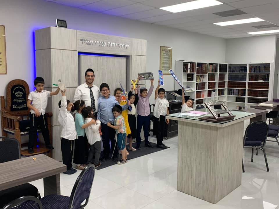 Children celebrating in the sanctuary with Rabbi Lasry
